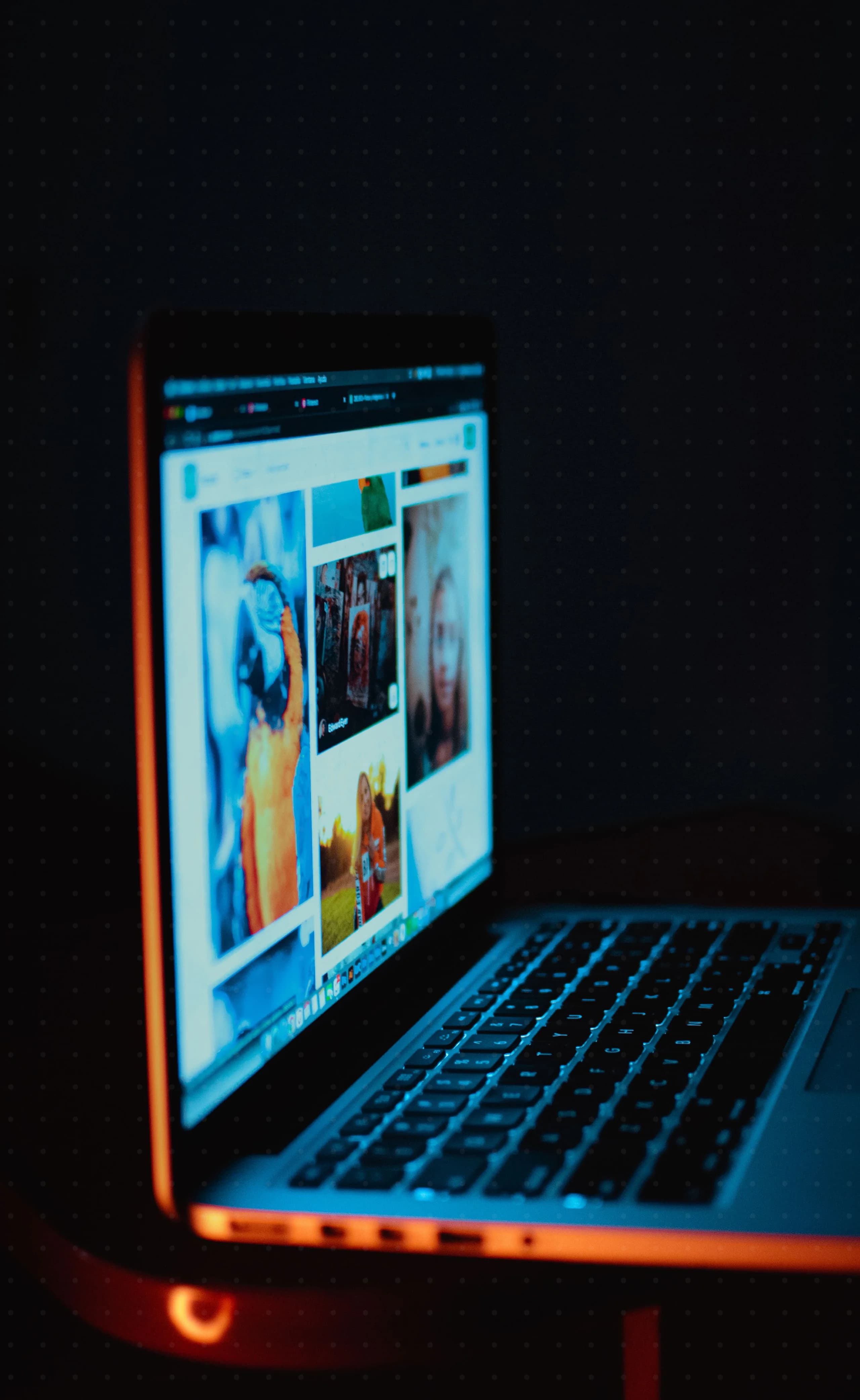 Laptop displaying code in a dark workspace with warm orange light