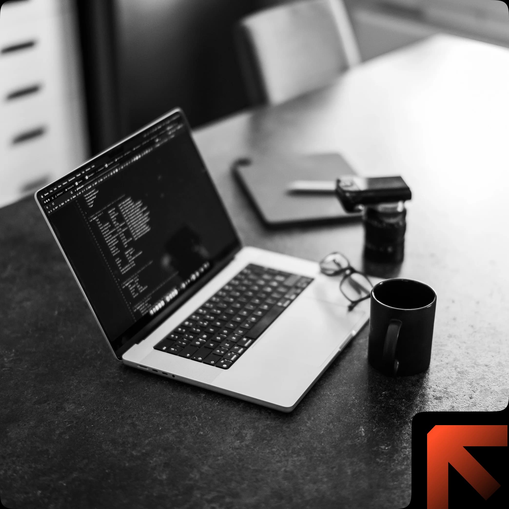 Workspace with a laptop, coffee mug, and glasses